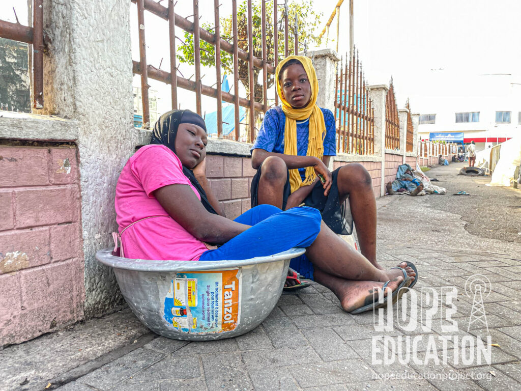Two kayaye resting in their bowls outside Makola Market, Accra