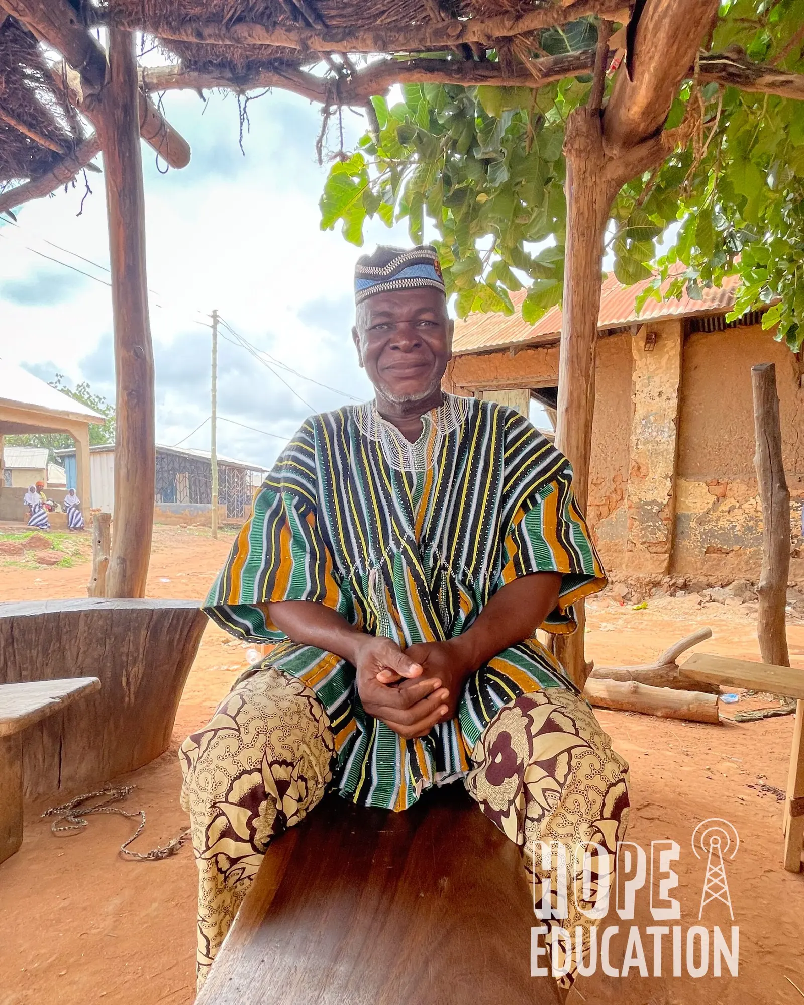 The Chief of Walewale meat market, Northern Region sits on a bench in his traditional smock or fugu in northern Ghana