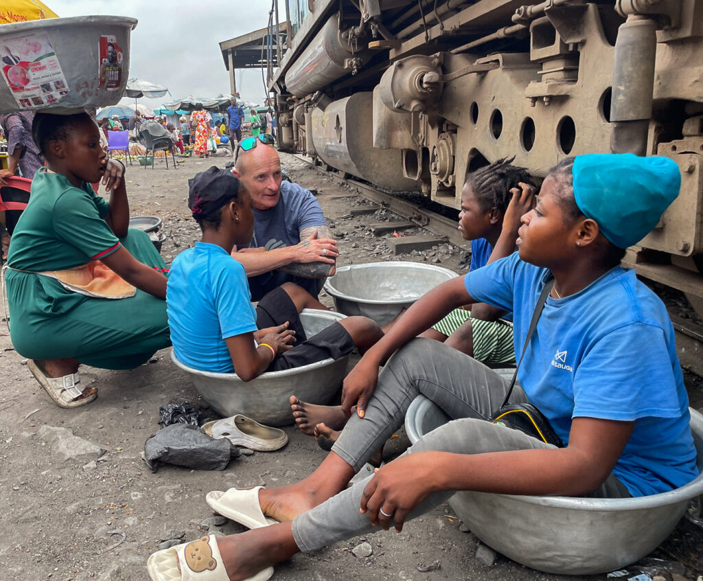 Angus Thomas of Hope Education Project talks with kayaye on the railway tracks, Accra