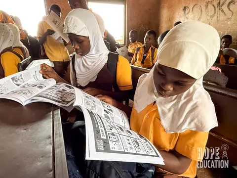 Students at Bagabaga Junior High School, Tamale reading the HEP human trafficking education program handout, filled with cartoons, quizzes, facts and revision notes.