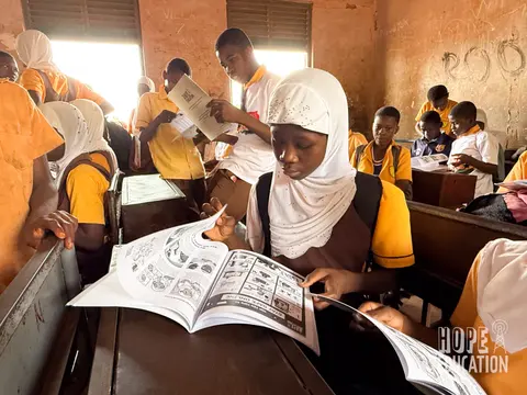 Students at Bagabaga Junior High School, Tamale reading the HEP human trafficking education program handout, filled with cartoons, quizzes, facts and revision notes.