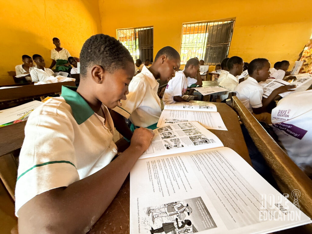Students at ST Pauls Junior High School, Tamale reading the HEP human trafficking education program handout, filled with cartoons, quizzes, facts and revision notes.