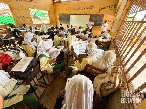 Students at Darrul Haddis Junior High School, Tamale reading the HEP human trafficking education program handout, filled with cartoons, quizzes, facts and revision notes.