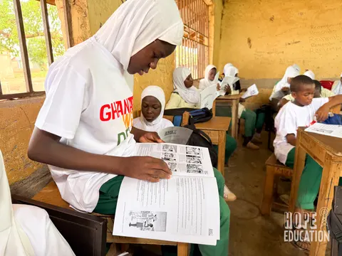 Students at Darrul Haddis Junior High School, Tamale reading the HEP human trafficking education program handout, filled with cartoons, quizzes, facts and revision notes.