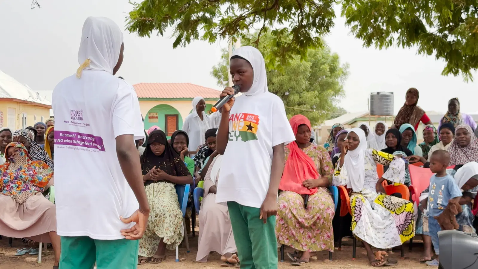 A student speaks to women and girls at a Hope Education Project community event in Tamale
